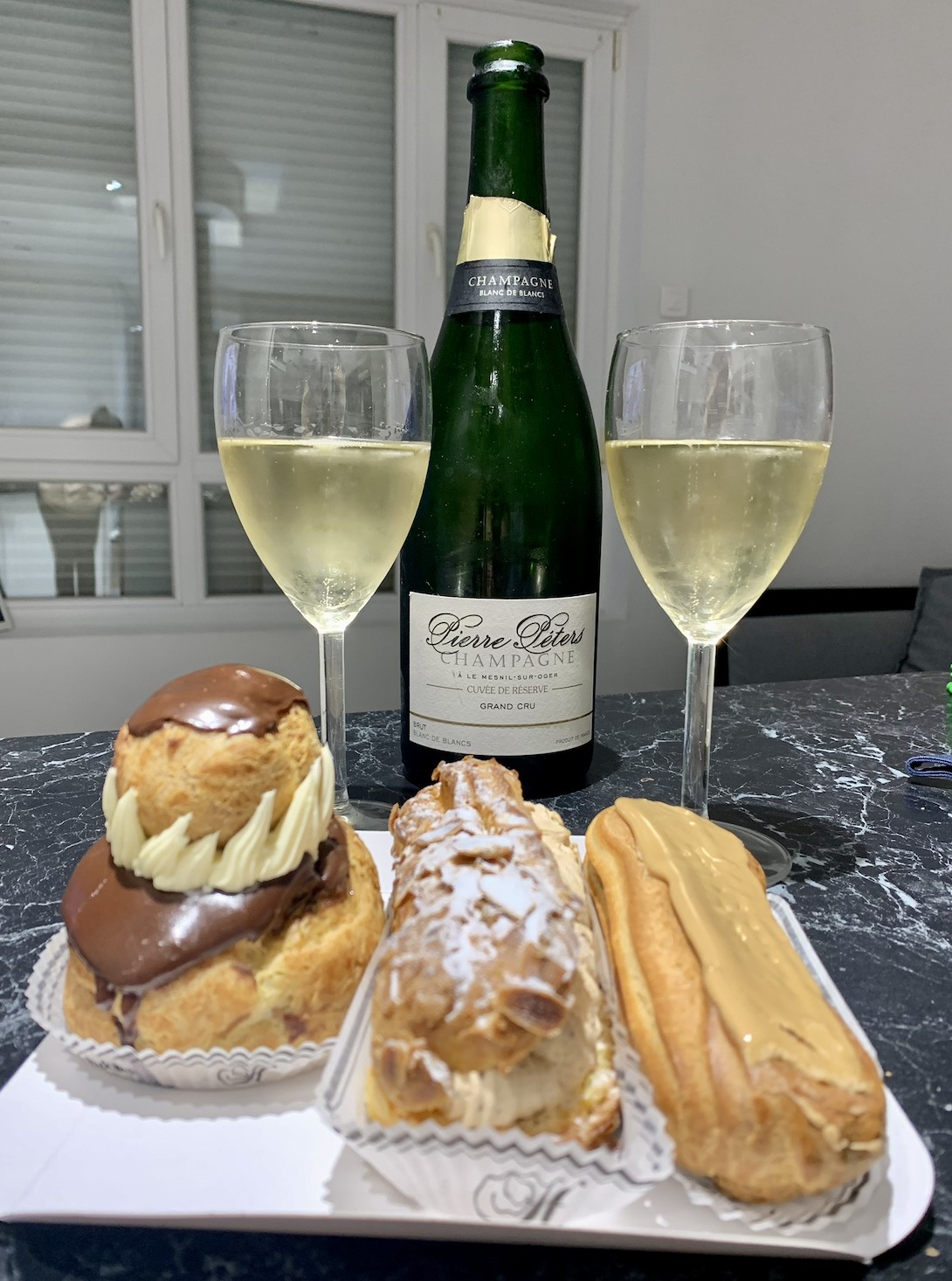 Bottle of Pierre Péters blanc de blancs champagne with pastries