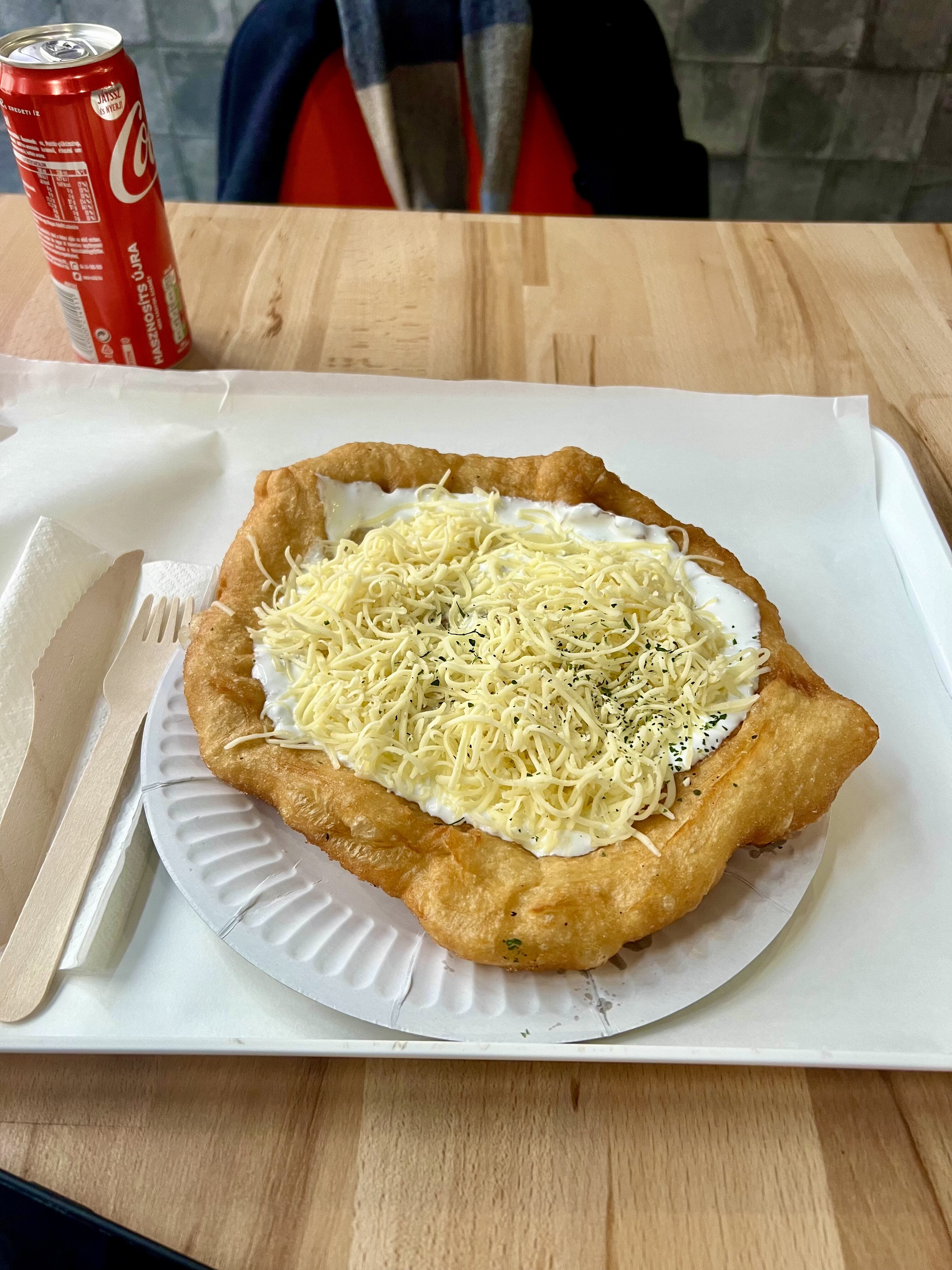 Lángos topped with sour cream and cheese in Budapest
