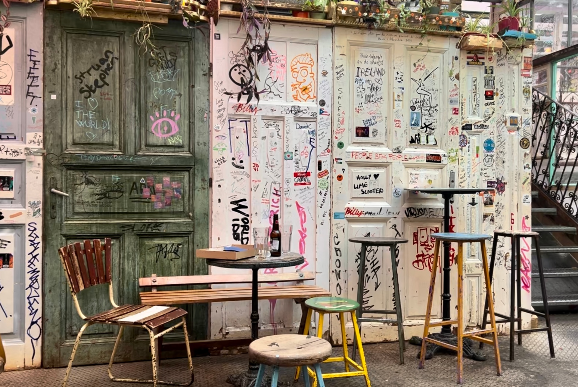 Inside Szimpla Kert ruin pub with graffiti-covered doors and mismatched furniture