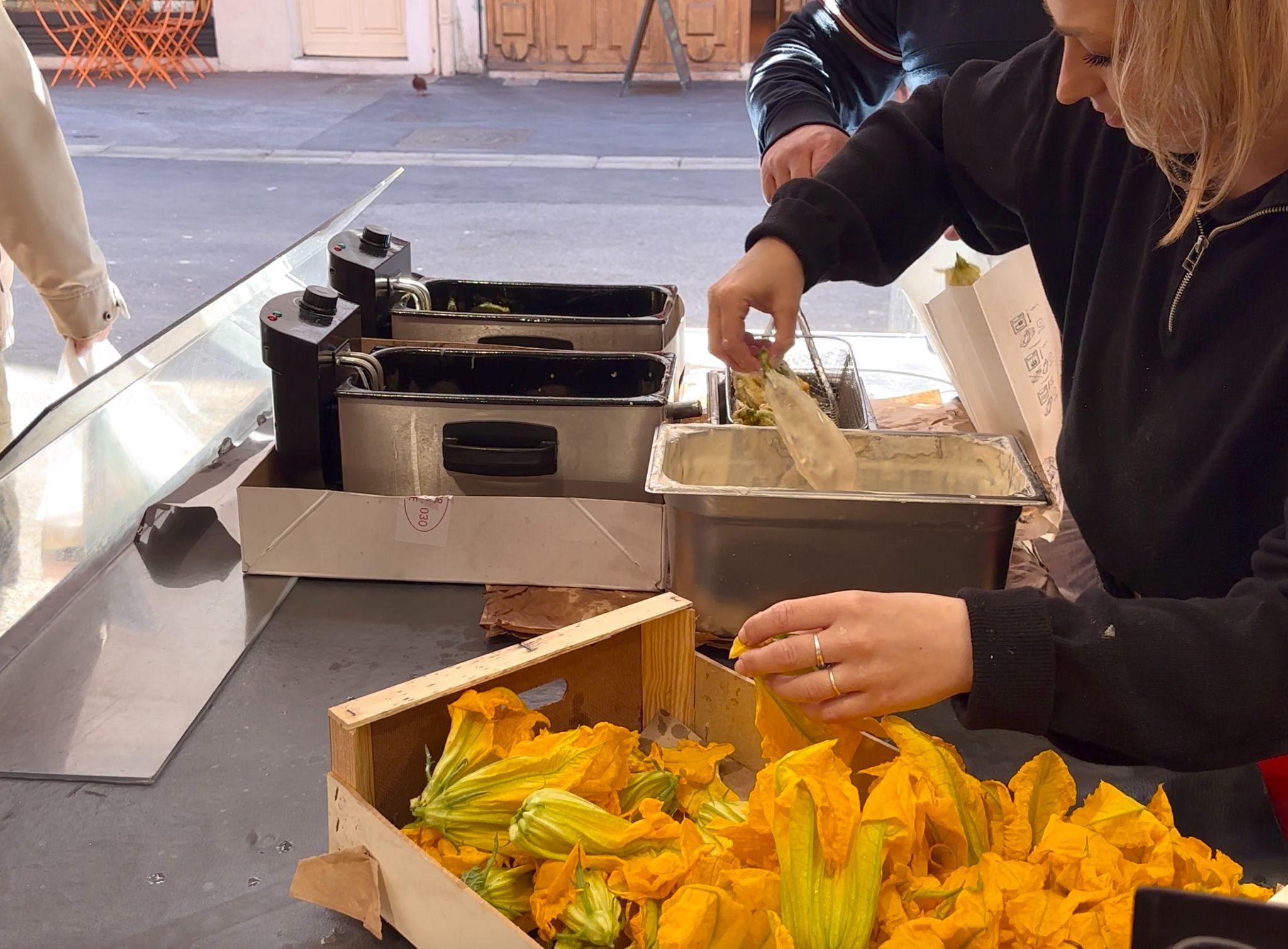 eating fried zucchini flowers at Marche Forville in Cannes, France