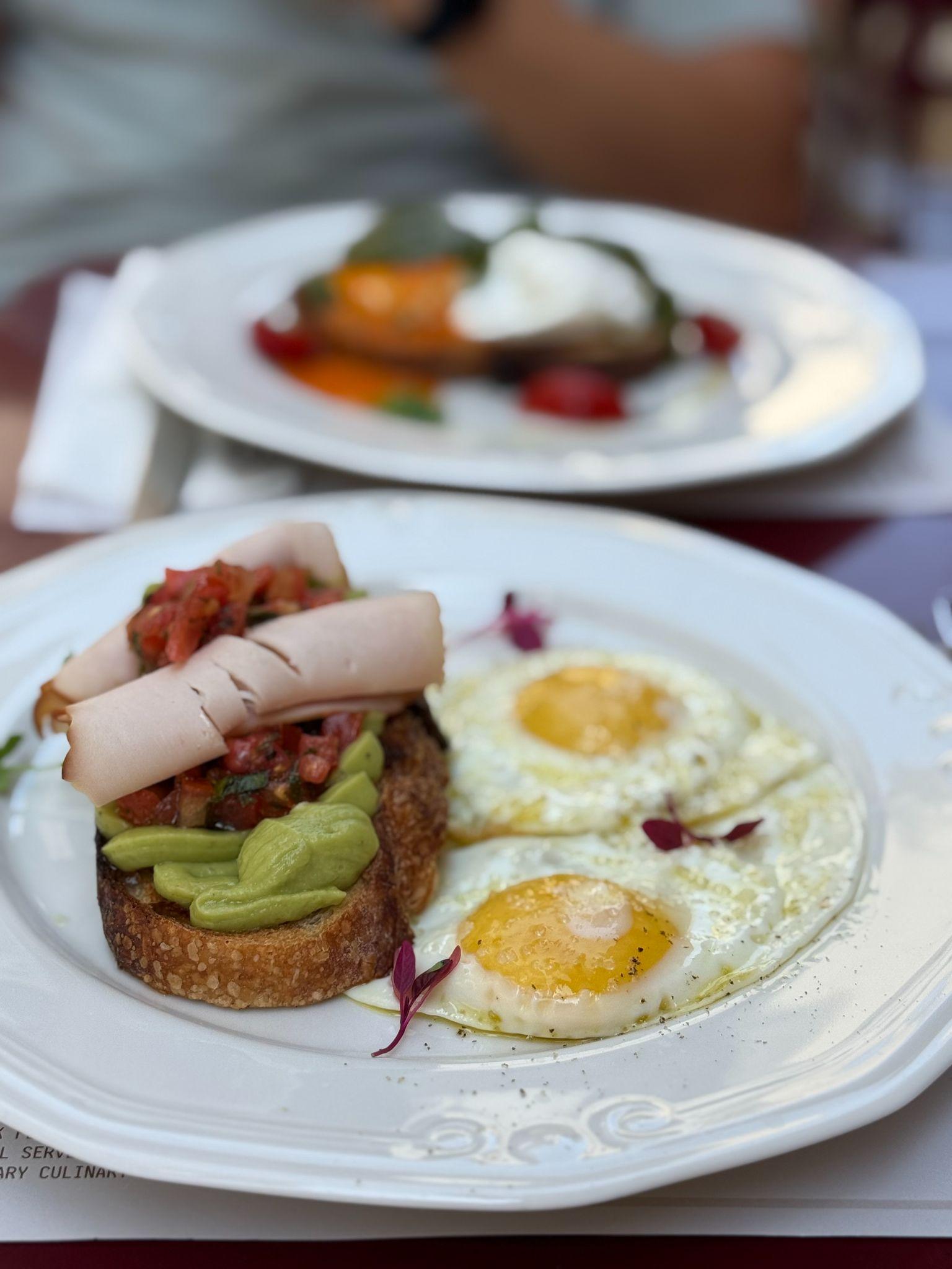 Brunch plates at Silo in Corfu Old Town with eggs, avocado on toast, and turkey