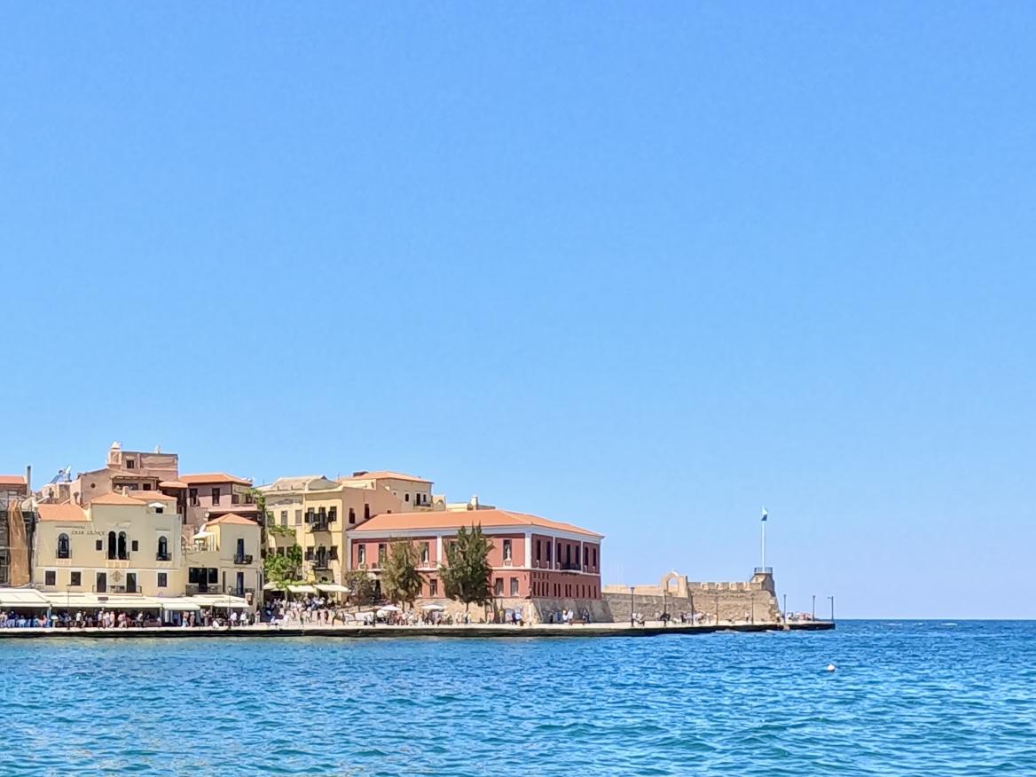 Chania harbor waterfront with colorful Venetian buildings and blue sea
