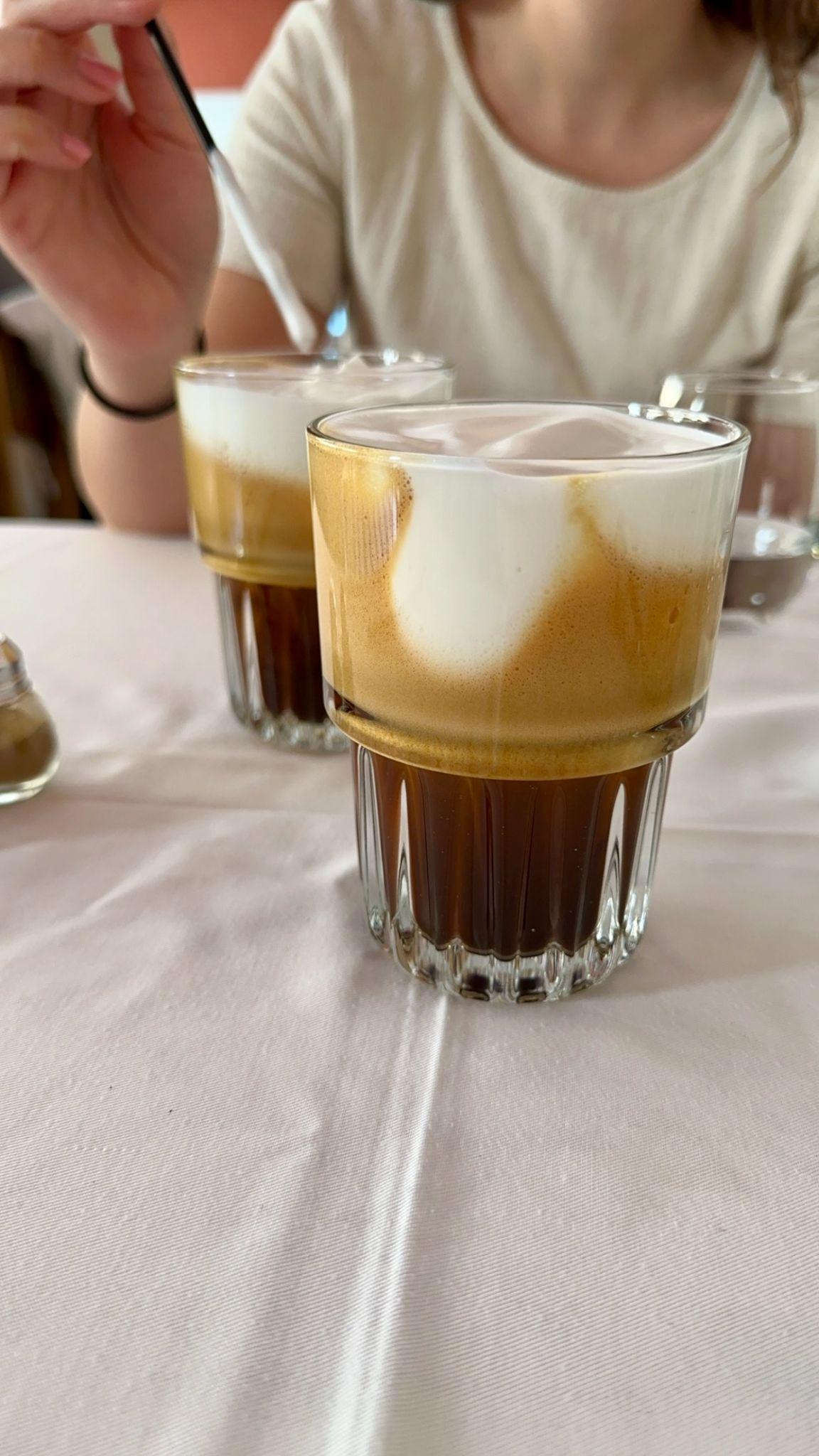 Two freddo cappuccinos on a white tablecloth at a café in Chania, Crete
