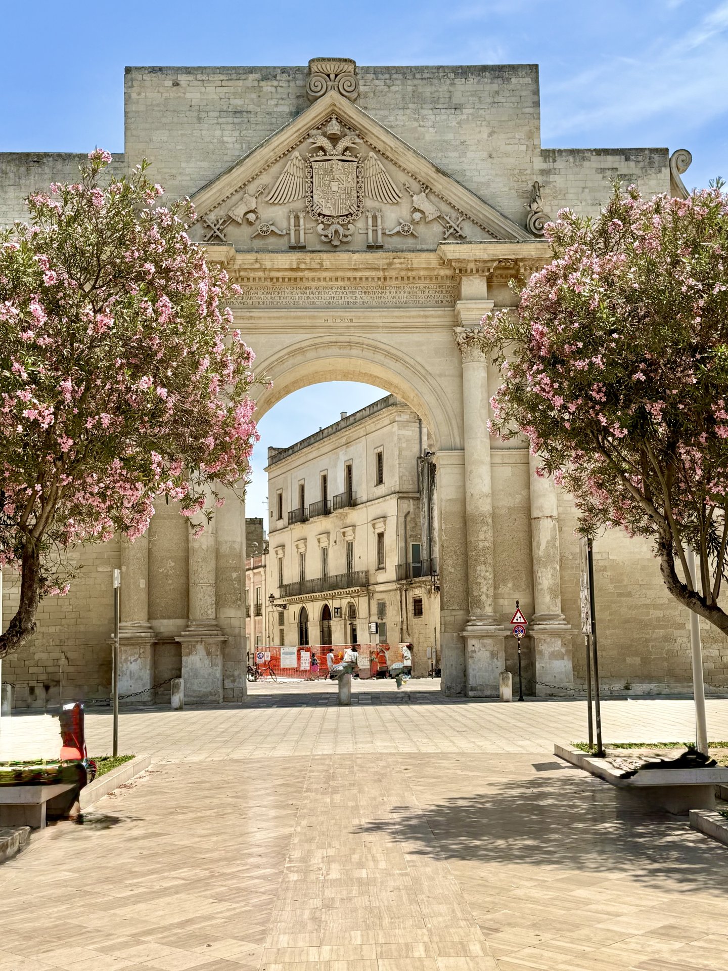 Porta Napoli gate in Lecce framed by blooming pink oleander trees