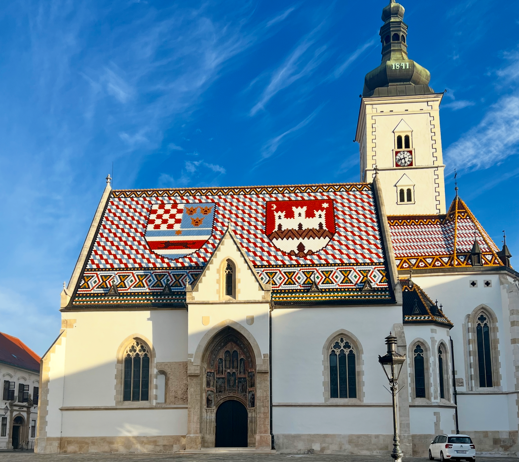 St. Mark's Church in Zagreb with its colorful tiled roof and clock tower against a blue sky